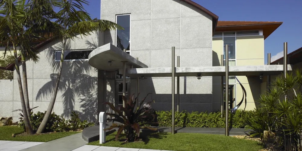 A secondary open breezeway connects to a guest suite. Featuring a mix of textured surfaces and lush plantings, the façade of the Hills House offers a contemporary look with a strong connection to the surrounding nature. Light, durable materials are used to enhance the architectural style and environmental harmony.
